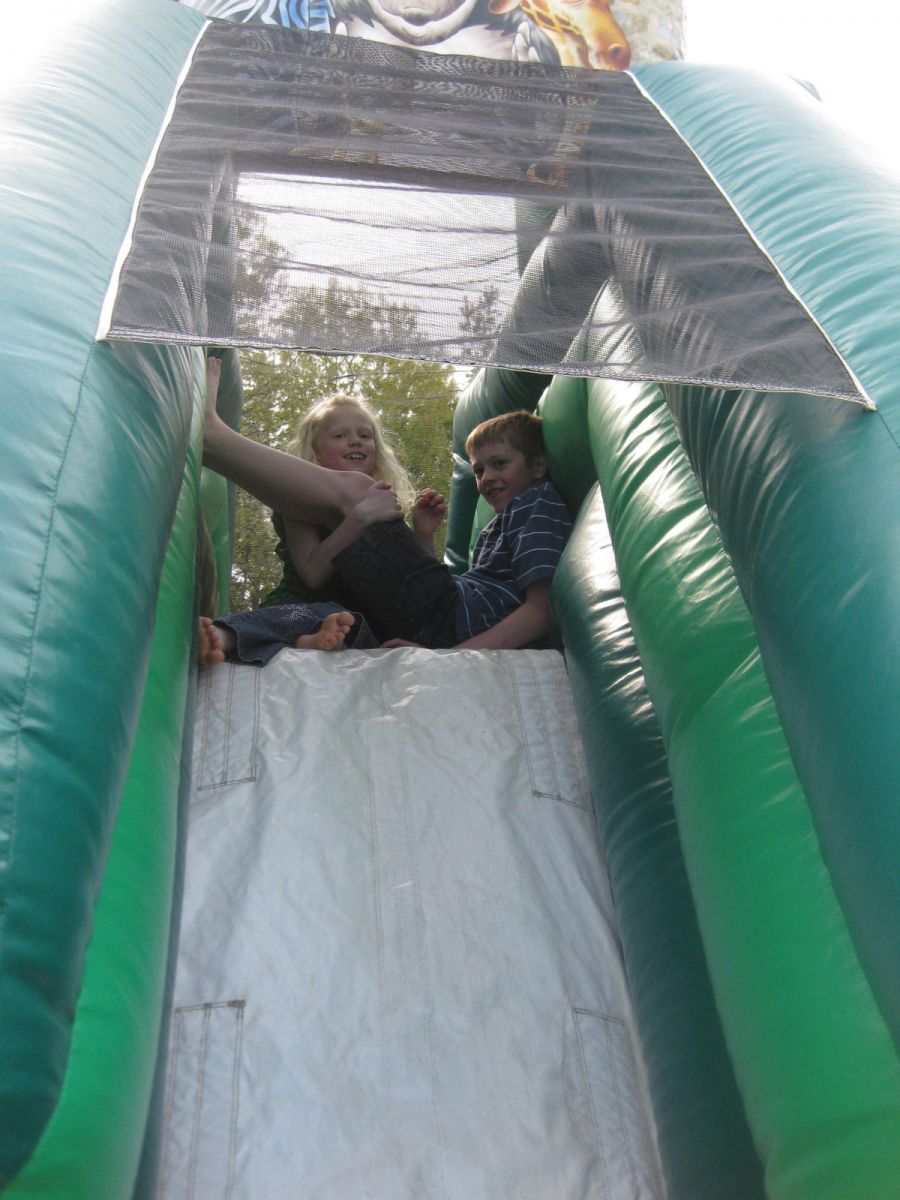 Two Pre-Teens Sitting at the top of the slide inside the Zoo Combo